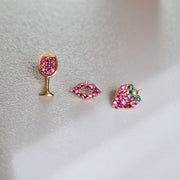14K gold garnet lips flat back earring styled with wine glass and strawberry earrings on soft surface