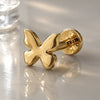 14k yellow gold butterfly flat back labret stud showing polished wings and flat disc backing, angled view