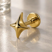 14k yellow gold sparkle flat back labret stud with four-point star charm, angled lifestyle shot