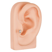 Pear diamond 14k gold cartilage stud shown in lobe piercing on silicone ear model for size reference