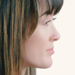 1.5mm black diamond bezel nose stud shown in pierced nose, side profile on model