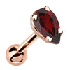 14k rose gold cartilage stud with pear-cut deep red garnet gemstone in 4-prong setting, angled view