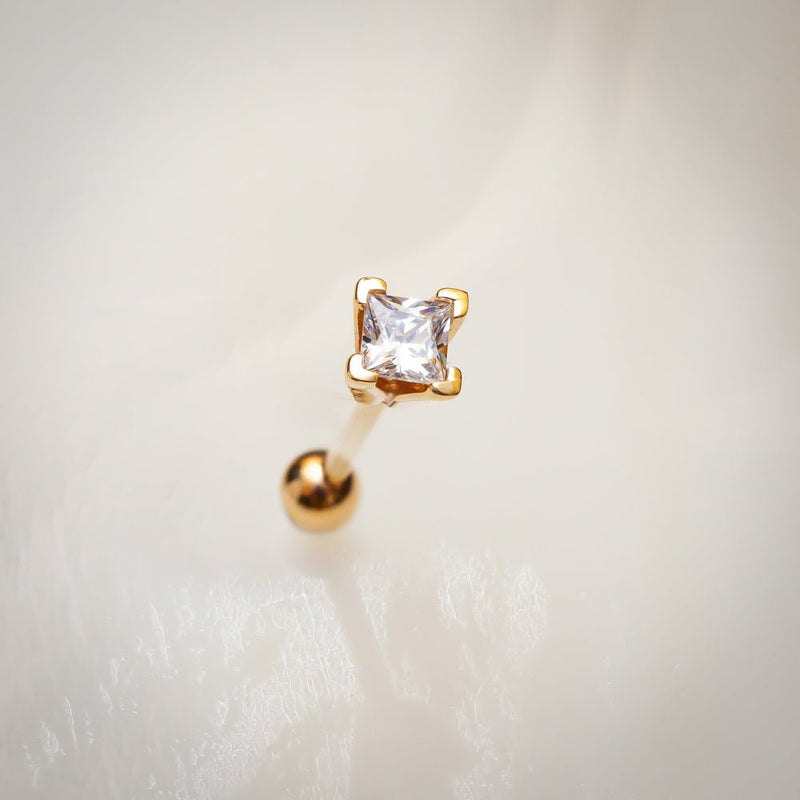 14k yellow gold princess cut diamond cartilage stud on soft white background, angled view