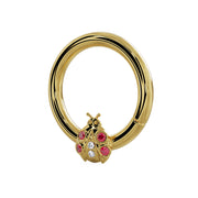 14K yellow gold ladybug seam ring with garnet and diamond accents, angled side view