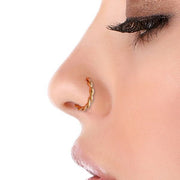 14K yellow gold twisted nose hoop worn in side-profile nostril piercing, showing hoop fit