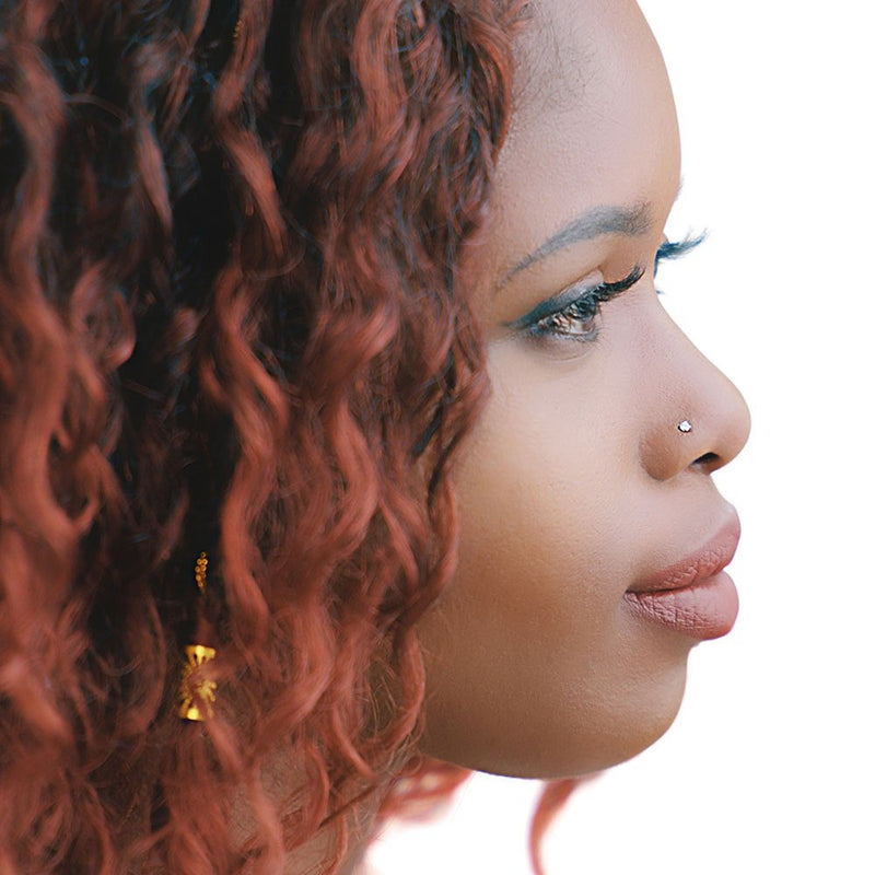 2.5mm CZ gold nose stud shown in pierced nostril on model, side profile demonstrating flush fit