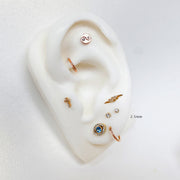 2.5mm diamond bezel flat back stud labeled on white ear mannequin in a styled multi-piercing display