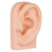 14k gold beaded bezel CZ cartilage stud on silicone ear model, lobe placement view