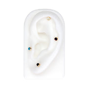 2mm opal flat back stud shown in helix piercing on white ear display with mixed gemstone studs