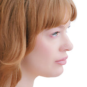 Side profile of model wearing 2mm diamond nose stud, showing delicate low-profile fit on nose