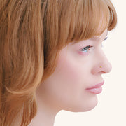 2mm yellow diamond bezel nose stud shown on pierced nose, side profile on model