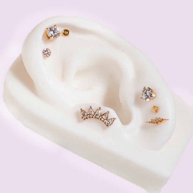 3mm diamond bezel flat back stud on white ear mannequin styled with mixed gold cartilage jewelry