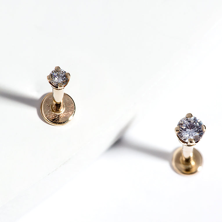 Two 14k gold 3mm CZ flat back labret studs shown upright on white surface, showcasing basket setting height