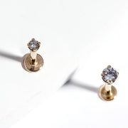 Two 3mm diamond 14k yellow gold flat back labret studs on white surface showing top and angle views