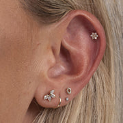 Pear fan diamond stud earring shown in lobe piercing alongside curated ear stack on model