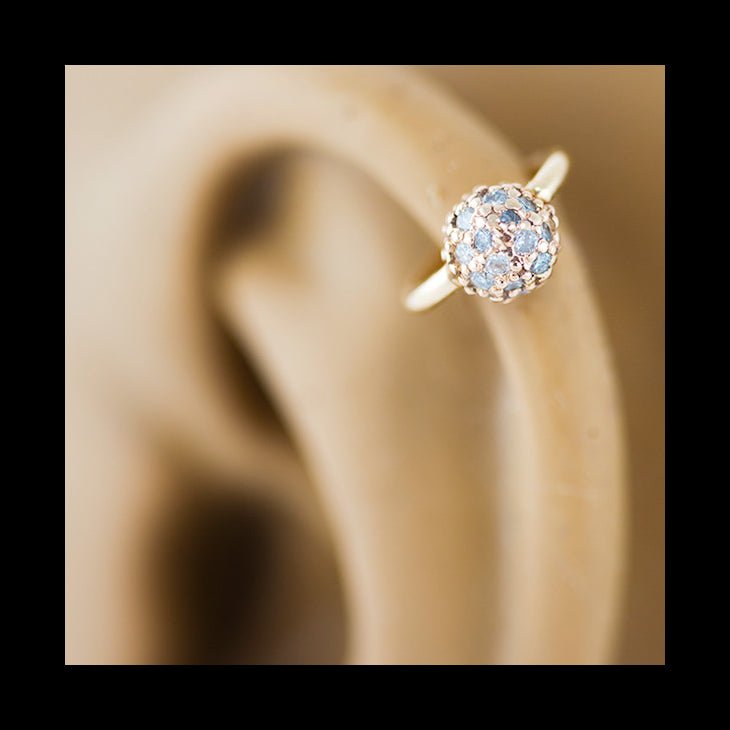 14K gold diamond pavé fixed bead ring shown in cartilage piercing, highlighting fit and ball scale