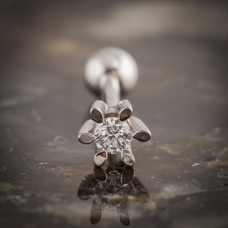 Close-up of 14k white gold diamond flower helix stud showing six-prong petal setting and diamond center