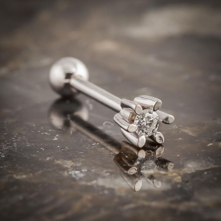 14k white gold diamond flower helix barbell resting on stone surface, side view showing full barbell length