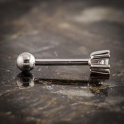 Side profile of 14k white gold diamond flower helix stud on stone surface highlighting barbell and petal base