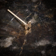 14K rose gold butterfly nose ring straight post style on dark marble surface
