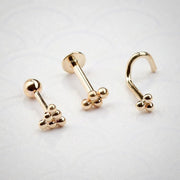 14K rose gold trinity bead design shown in barbell, labret, and nose screw styles