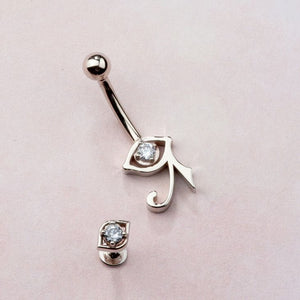 14K white gold all-seeing eye labret stud beside a larger Eye of Horus belly ring for style comparison