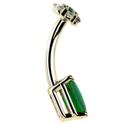 Side profile of 14k yellow gold belly ring showing curved barbell depth and green CZ setting edge