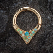 14K yellow gold opal clicker ring with V-shaped setting, displayed on dark stone surface