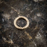 14K yellow gold segment ring closed, flat lay on dark marble showing polished finish