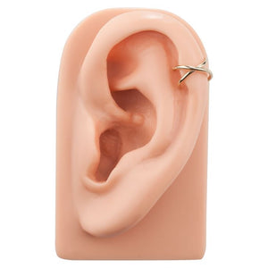 14k gold criss cross ear cuff shown on ear model at the helix, demonstrating fit and scale