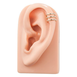 14k yellow gold triple-band ear cuff shown on ear model at the helix for fit reference