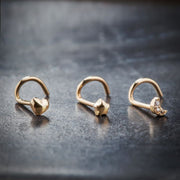 14k gold puffy heart nose ring shown alongside star and moon styles for size comparison