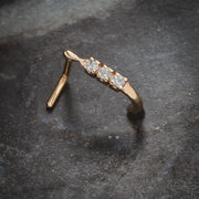 14K rose gold trinity diamond faux hoop nose ring resting on stone surface, angled lifestyle shot