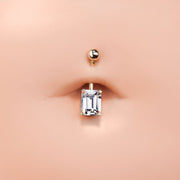 14k rose gold emerald-cut CZ navel ring shown in pierced belly button for fit and scale