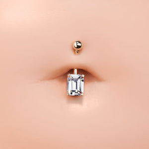 14k rose gold emerald-cut CZ navel ring shown in pierced belly button for fit and scale