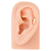 14K yellow gold bar stud in tragus piercing on silicone ear model showing placement and size