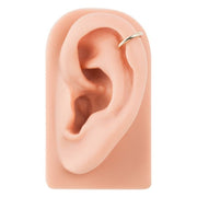 14k yellow gold band ear cuff positioned on silicone ear model showing conch placement and fit