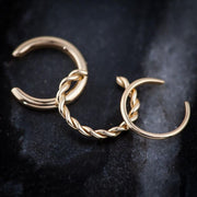 14k gold thin band ear cuff alongside twisted band styles on dark stone surface