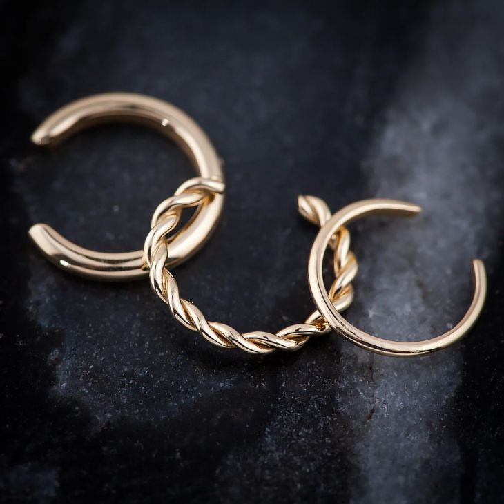 14k gold thin band ear cuff alongside twisted band styles on dark stone surface