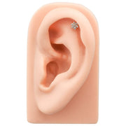 Diamond flower 14k gold flat back labret shown in helix piercing on silicone ear model for fit reference