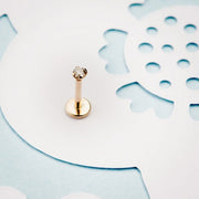 14k yellow gold 2mm diamond flat back labret stud displayed upright on decorative paper background