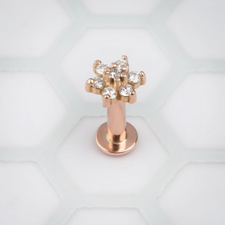 14k rose gold CZ flower flat back labret, front view showing clear stone petals on white background