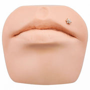 Rose gold CZ flower flat back labret shown in monroe lip piercing placement on silicone display model