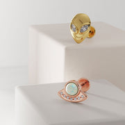 14K yellow gold alien diamond labret displayed alongside a rose gold UFO opal flat back earring