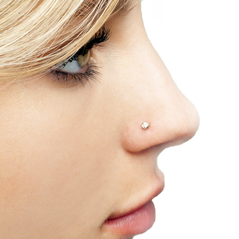 2.5mm diamond bezel flat back stud shown in nose piercing on model, side profile view