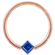 14k rose gold fixed bead ring with blue princess-cut CZ in corner bezel mount, front view