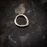 14K yellow gold CZ V-shape clicker ring flat lay on dark stone surface, angled top view