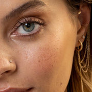 2mm diamond bezel nose stud in piercing styled alongside gold cartilage earrings