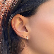 14k gold lightning bolt flat back stud worn in second lobe piercing on model, paired with cross and cartilage studs