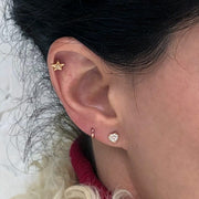 14k gold diamond star flat back stud worn in cartilage piercing, styled with other gold ear jewelry